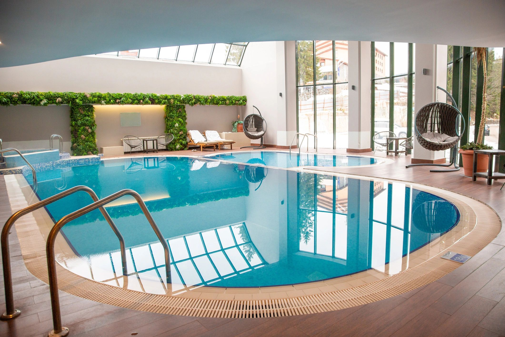 Indoor pool lounge with greenery and resort-like atmosphere